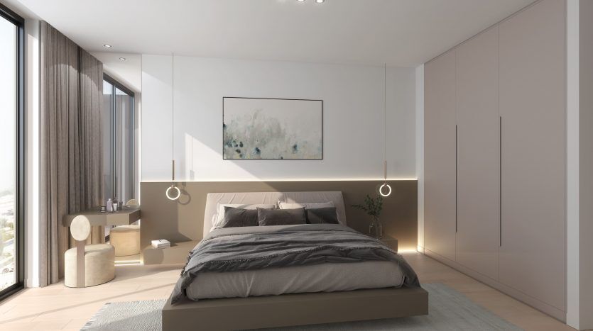 Une chambre moderne comprenant un grand lit avec des draps gris, une décoration minimaliste, des suspensions et une peinture abstraite au-dessus du lit dans un espace lumineux et aéré d'une villa de Dubaï.