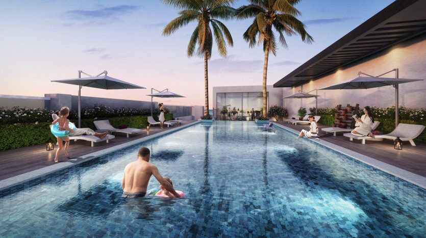 Les gens se détendent au bord d’une luxueuse piscine sur le toit au coucher du soleil, avec des palmiers et des chaises longues, surplombant le paysage urbain de Dubaï.