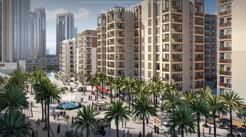 Une représentation artistique du quartier de Creek Beach par Emaar, avec des promenades animées avec des gens, des palmiers et des immeubles d'appartements modernes de hauteur moyenne sous un ciel clair à Dubaï.