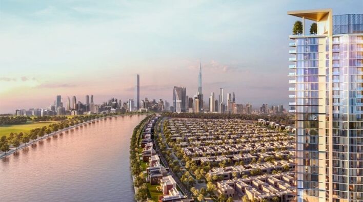 Une vue panoramique sur les toits de la ville au coucher du soleil, avec des gratte-ciel modernes, une rivière et des rangées de maisons de banlieue à Dubaï, vue depuis un balcon de grande hauteur.