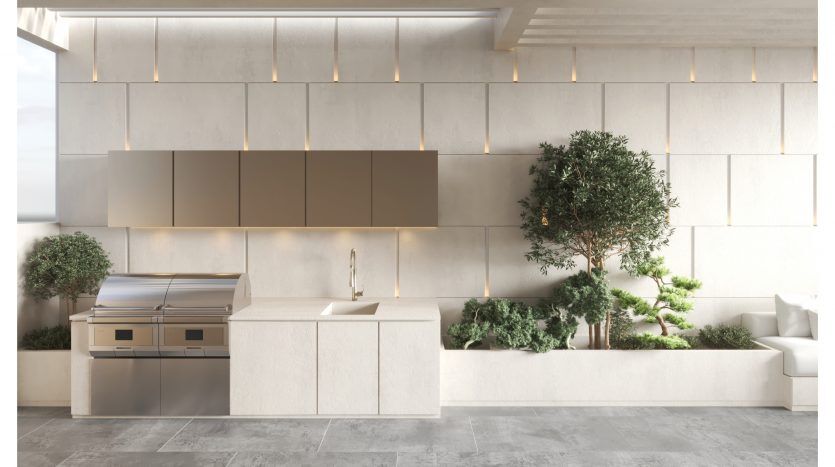 Cuisine moderne dans un appartement de Dubaï au design élégant et minimaliste, comprenant des armoires en bois clair, des appareils électroménagers intégrés en acier inoxydable et un petit jardin intérieur avec deux arbres. Les tons neutres dominent l'espace aéré et ensoleillé