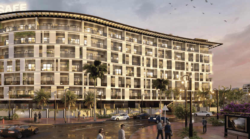 Un hôtel moderne de plusieurs étages avec une façade incurvée au coucher du soleil, situé à Dubaï. On voit des gens marcher et des voitures sont garées devant, entourées de palmiers et de lampadaires. Les oiseaux volent en rose