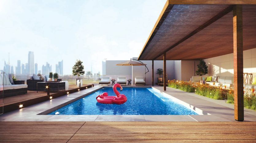 Une piscine luxueuse sur le toit d'une villa à Dubaï avec un flotteur de flamant rose, entourée de chaises longues et un horizon de la ville en arrière-plan, vue depuis sous un patio ombragé.