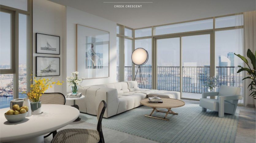 Salon moderne dans une villa de Dubaï avec de grandes fenêtres donnant sur le port de Dubai Creek, comprenant un canapé blanc, un coin repas et une décoration artistique. La pièce dégage une ambiance sereine et lumineuse.