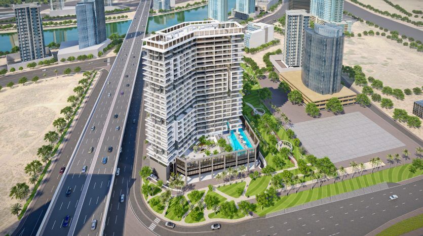 Vue aérienne d'un immeuble moderne à plusieurs niveaux avec piscine, situé dans un coin de ville près d'une autoroute à Dubaï, avec des gratte-ciel voisins et une rivière.