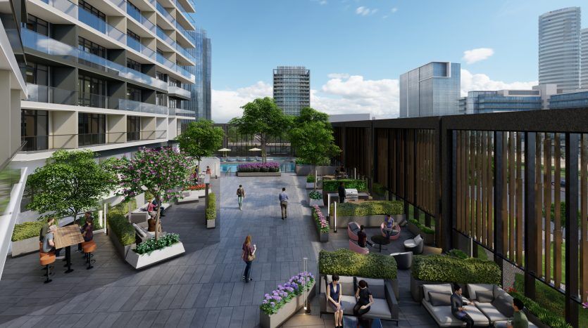 Place urbaine moderne entre des immeubles de grande hauteur, avec des sentiers pédestres, des coins salons avec une verdure luxuriante et des gens profitant du plein air sous un ciel clair à Dubaï.