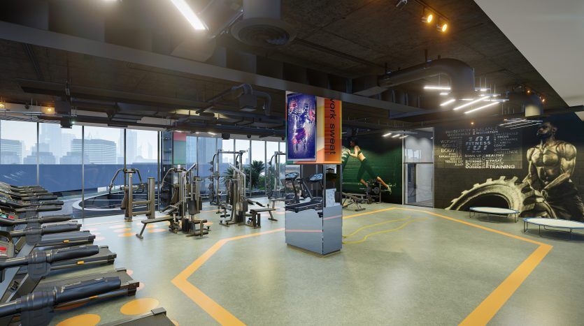 Intérieur de salle de sport moderne avec tapis roulants, appareils de musculation et espace d'entraînement fonctionnel, doté de grandes fenêtres avec vue sur la ville de Dubaï et d'affiches de motivation sur les murs.