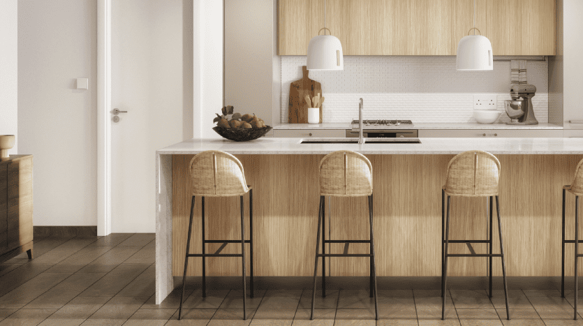 Intérieur de cuisine moderne avec parquet, îlot de cuisine avec tabourets de bar en rotin, suspensions blanches et armoires en bois dans une villa de Dubaï.