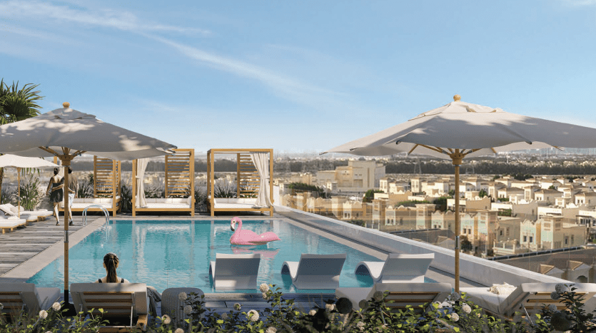 Piscine luxueuse sur le toit avec chaises longues et grands parasols, surplombant un paysage urbain pittoresque de Dubaï. Deux personnes se détendent, l'une sur un flotteur rose et l'autre au bord de la piscine.