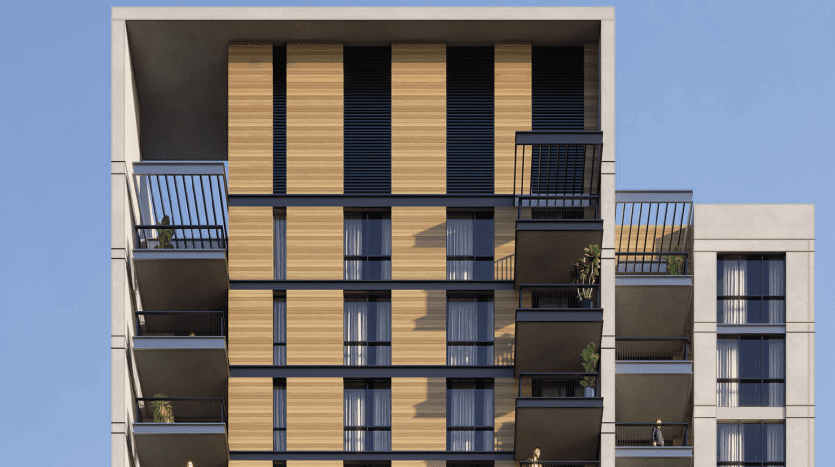 Façade d'immeuble d'appartements moderne présentant un mélange de lambris en bois et de béton gris, avec des balcons sur un ciel bleu clair à Dubaï.