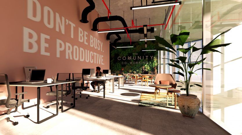 Espace de coworking moderne à Dubaï avec lumière naturelle, avec un slogan « ne soyez pas occupé, soyez productif » sur le mur, des bureaux avec des ordinateurs et des plantes vertes luxuriantes.