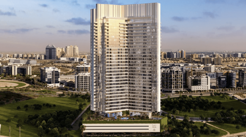 Un appartement résidentiel moderne de grande hauteur à Dubaï au design élégant, entouré de parcs verdoyants et d'autres développements urbains sous un ciel dégagé.
