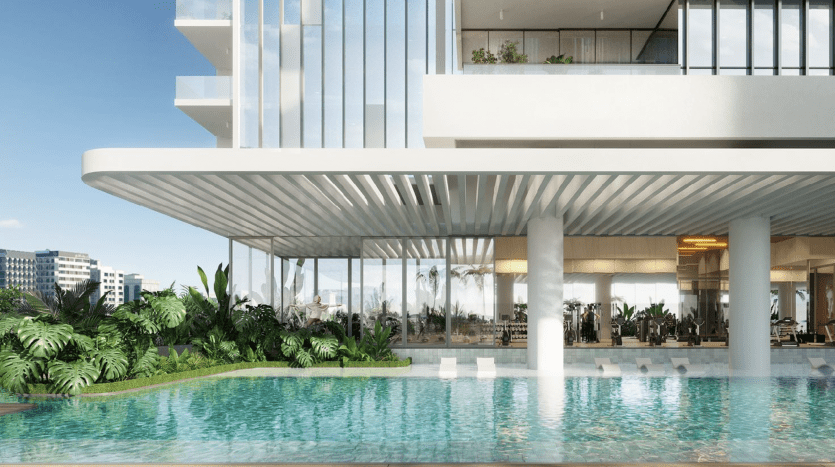 Complexe de luxe moderne doté d'une grande piscine extérieure entourée de palmiers, présentant une élégante architecture blanche avec de vastes balcons et un cadre tropical luxuriant, parfait pour ceux qui recherchent un investissement à Dubaï.