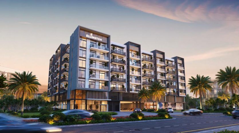 Hôtel Blaketon moderne à plusieurs étages au crépuscule à Dubaï, doté de fenêtres éclairées et d'un panneau bien visible, le long d'une rue animée avec des voitures floues en mouvement.