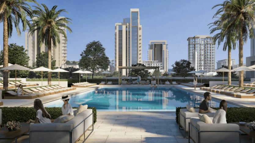 Cadre luxueux au bord de la piscine avec des groupes de personnes se relaxant sur des chaises longues et des canapés, entouré de grands palmiers et d'immeubles modernes de grande hauteur dans une oasis urbaine ensoleillée de Dubaï.