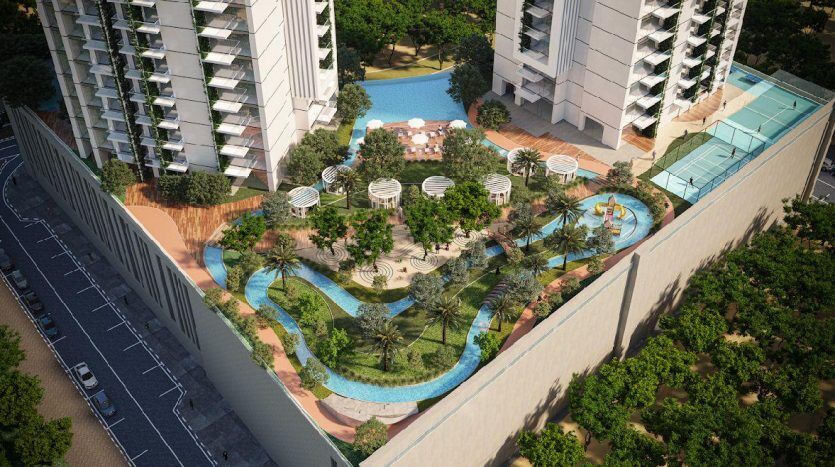 Vue aérienne d'un complexe résidentiel luxueux à Dubaï comprenant des piscines incurvées, une verdure luxuriante, des espaces de détente et des immeubles modernes de grande hauteur par une journée ensoleillée.