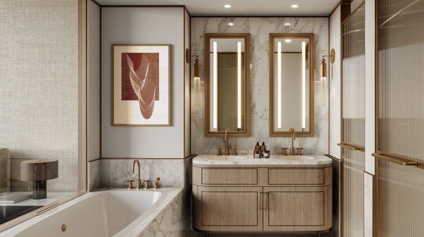 Salle de bains luxueuse dans une villa de Dubaï avec des murs en marbre comprenant une baignoire à gauche, un meuble-lavabo double en bois au centre et des miroirs aux cadres dorés au-dessus de chaque lavabo. L'œuvre d'art est accrochée au