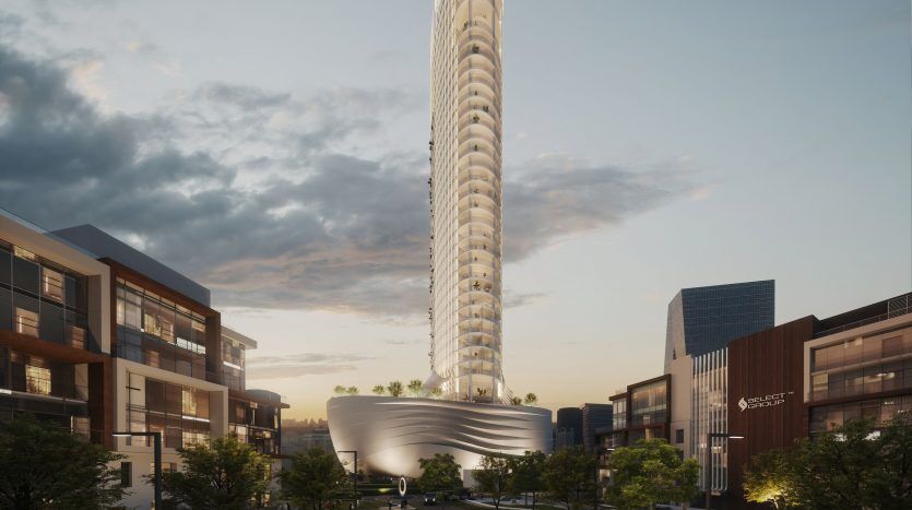 Un gratte-ciel futuriste avec un sommet en spirale se dresse bien en évidence dans un cadre urbain au crépuscule à Dubaï. Les bâtiments inférieurs environnants sont éclairés et on peut voir des gens se promener dans les rues.