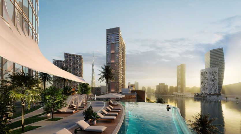 Une luxueuse piscine sur le toit au coucher du soleil, avec des chaises longues élégantes et une verdure luxuriante surplombant un paysage urbain pittoresque avec des gratte-ciel modernes à Dubaï.