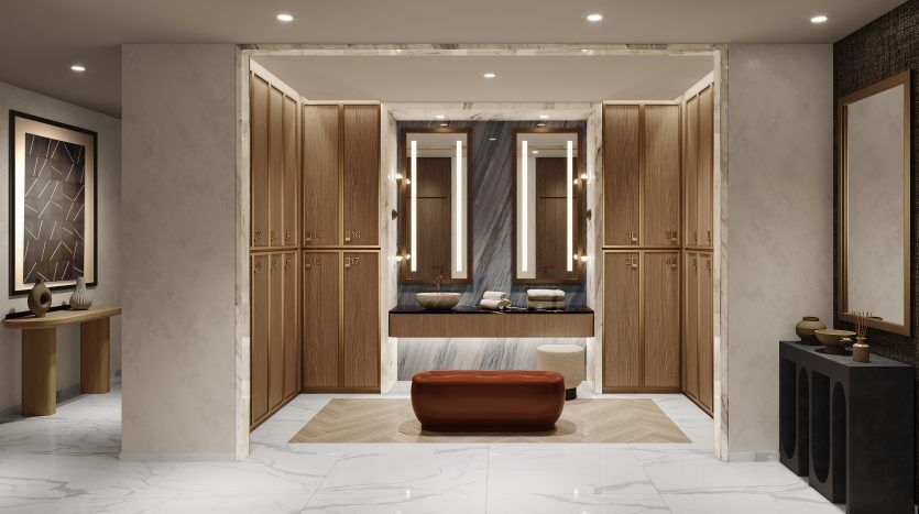 Luxueux dressing avec armoires en bois de chaque côté, un élégant coin salon central et un dressing visible à l'arrière avec miroirs et panneaux lumineux dans un prestigieux appartement Dubaï.