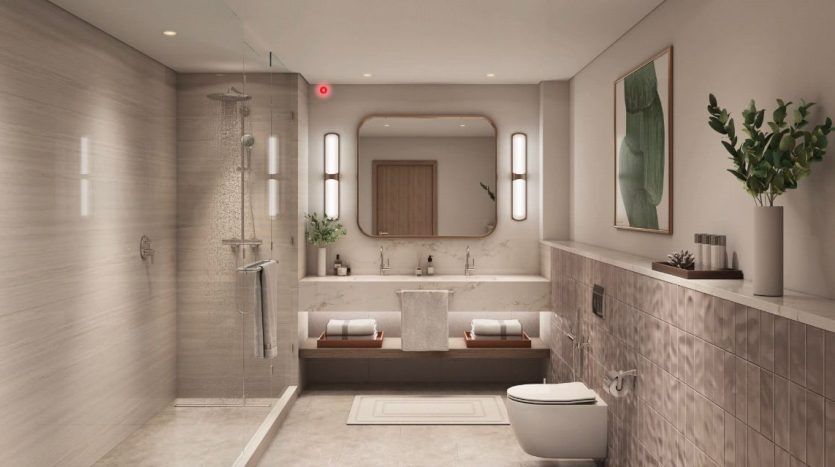 Modern, elegant bathroom in a Dubai apartment featuring a glass shower, white bathtub, two sinks with mirrors and toilet, complemented by earth-toned tiles and green plants.