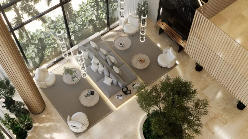 Vue aérienne d'un luxueux salon intérieur dans une villa de Dubaï au décor moderne, comprenant des canapés, des chaises et des tables basses, entouré de grandes fenêtres mettant en valeur la verdure luxuriante à l'extérieur.