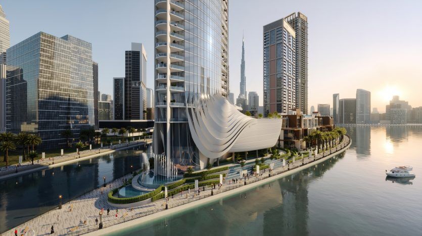 Un paysage urbain futuriste au coucher du soleil avec des gratte-ciel modernes, un bâtiment innovant en forme de vague au bord de l'eau, symbole de l'investissement Dubaï, et une promenade avec quelques piétons. Deux bateaux flottent