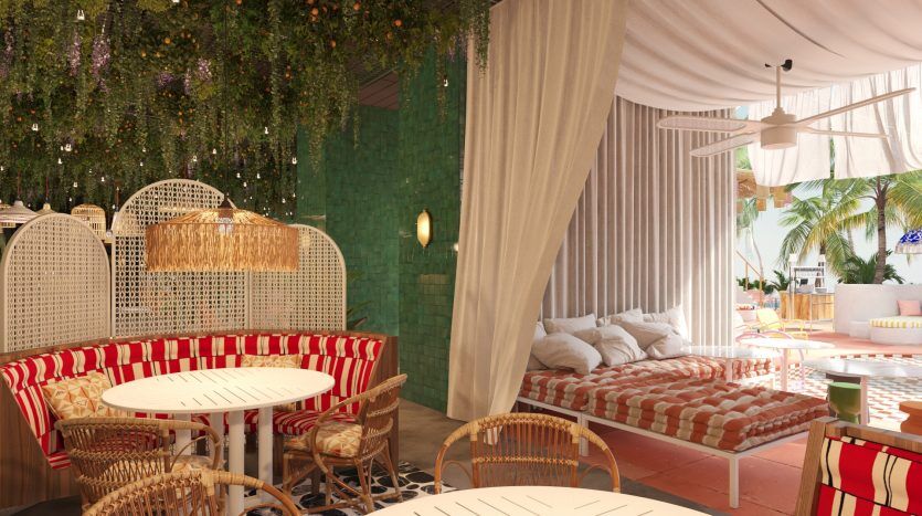 Un café en plein air animé et élégant avec une ambiance tropicale, avec des meubles en rotin, des tissus d'ameublement floraux, des plantes vertes suspendues et un éclairage chaleureux. Idéal pour ceux intéressés par l'investissement à Dubaï.