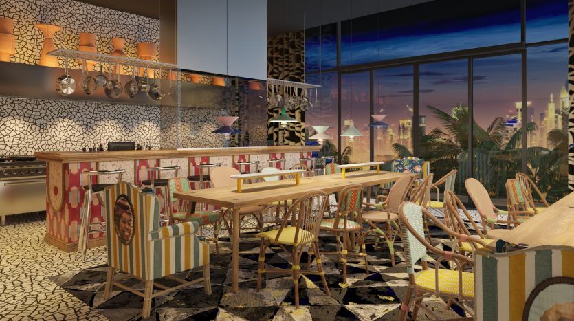 Intérieur de restaurant moderne à la décoration éclectique, comprenant des chaises à motifs, un bar carrelé, des verres suspendus et une vue panoramique sur la ville de Dubaï à travers de grandes fenêtres au coucher du soleil.