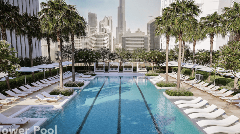 Une luxueuse piscine extérieure entourée d'une verdure luxuriante et de chaises longues, avec d'imposants gratte-ciel visibles en arrière-plan, parfaite pour ceux qui cherchent à investir à Dubaï.