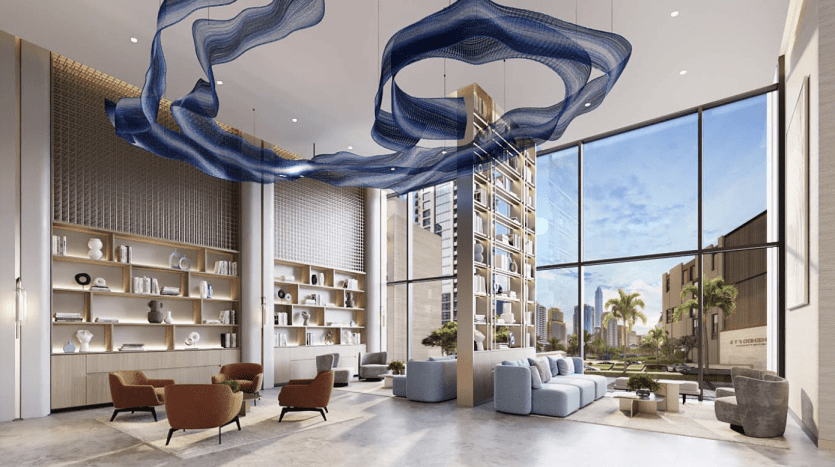 Le hall d'entrée de l'hôtel moderne présente une décoration élégante comprenant une vaste étagère, des sièges moelleux, de grandes fenêtres offrant une vue sur le paysage urbain de Dubaï et une superbe installation artistique bleue au-dessus.