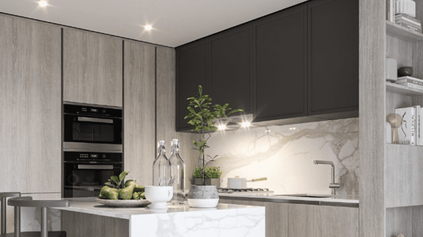 Intérieur de cuisine moderne avec armoires en bois stratifié, placards sombres, appareils électroménagers intégrés, comptoirs en marbre et petit coin repas avec chaises en métal dans un appartement de Dubaï. Le décor comprend des plantes vertes et élégantes