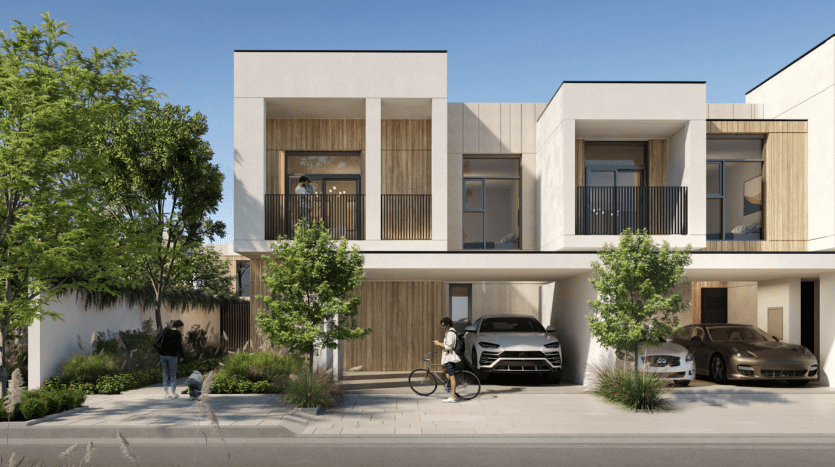 Maisons en rangée modernes aux lignes épurées, dotées de façades en bois et en béton, de grandes fenêtres et de balcons. Cette villa à Dubaï dispose d'une rue paysagée avec des voitures garées, un cycliste et une personne