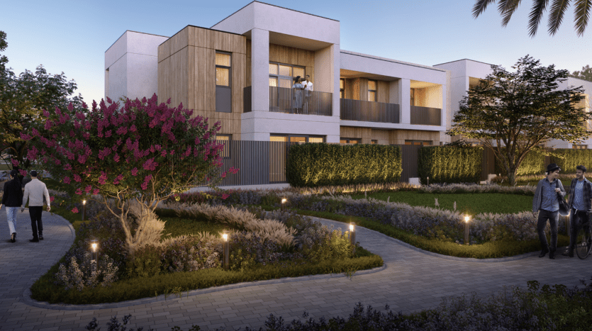 Immeuble résidentiel moderne avec balcons au crépuscule, entouré de jardins et de sentiers magnifiquement paysagers à Dubaï, où se trouvent des individus marchant et faisant du vélo.