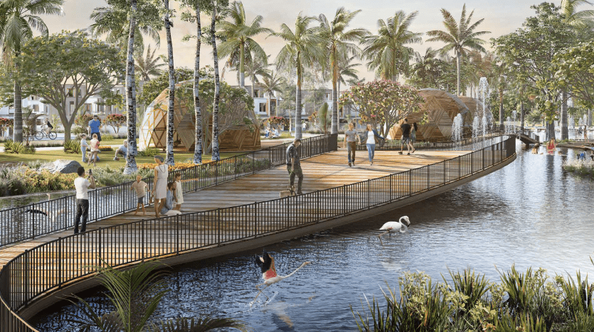 Un parc public animé avec des gens pratiquant diverses activités le long d'une promenade en bois au bord d'une voie navigable pittoresque, entouré d'une verdure luxuriante et de palmiers, souvent fréquenté par les clients de l'agence voisine.