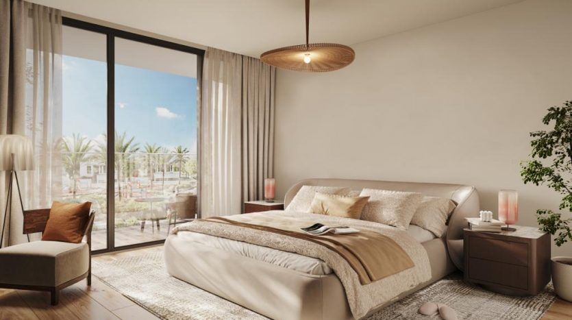 Une chambre moderne dans une villa à Dubaï avec un grand lit, une literie beige et marron et une vue sur les palmiers à travers des baies vitrées. Comprend une chaise, des plantes et un élément minimaliste
