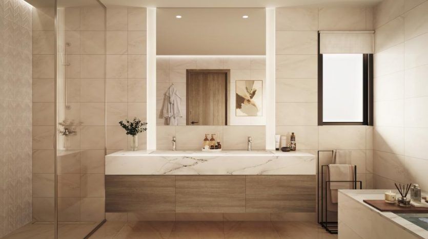 Un intérieur de salle de bains moderne dans une villa de Dubaï avec des carreaux de marbre beige, comprenant un grand miroir, une vanité sous-éclairée et des fleurs décoratives à côté de bouteilles de toilette minimalistes.