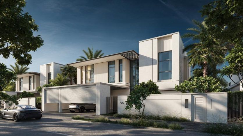 Rue résidentielle moderne de Dubaï comprenant des villas blanches contemporaines à deux étages dotées de toits plats, de grandes fenêtres et de garages attenants. Une verdure luxuriante et des voitures garées renforcent l'atmosphère tranquille de la banlieue.