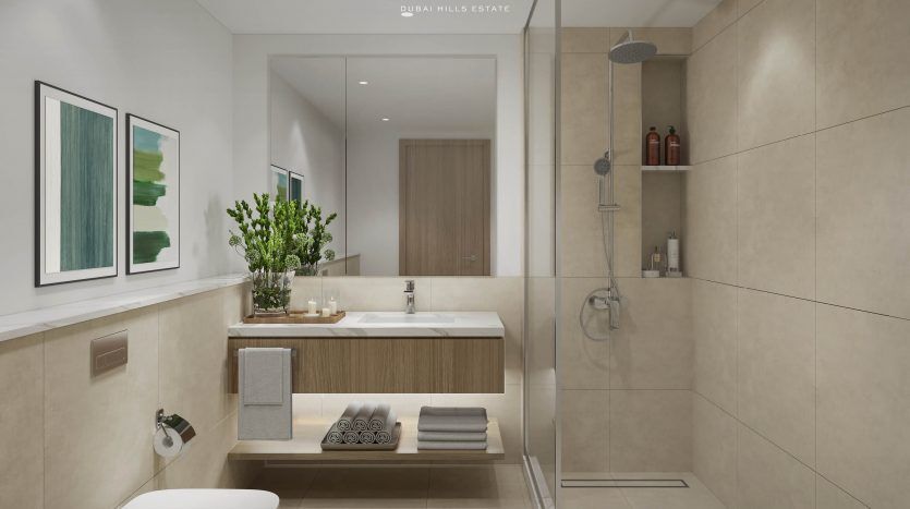 Salle de bain moderne dans une villa de Dubaï avec carrelage beige, vanité en bois, miroir, douche à l'italienne, plantes décoratives et œuvres d'art au mur. Les serviettes sont soigneusement empilées et un logo "E