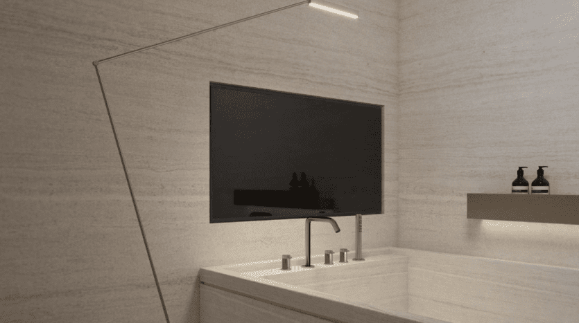 Une salle de bains moderne dotée d'un lavabo intégré élégant avec un seul robinet, d'une grande télévision murale et d'un éclairage minimaliste, le tout entouré de murs beiges texturés dans une villa exclusive à Dubaï.