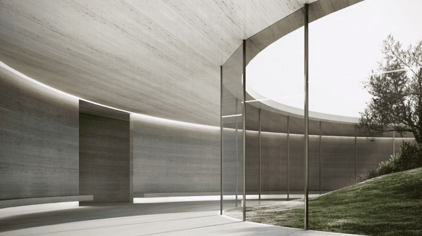 Conception architecturale moderne avec des structures en béton curvilignes et des panneaux de verre sans soudure, entourées d'une pelouse bien entretenue dans un cadre serein d'une villa à Dubaï.