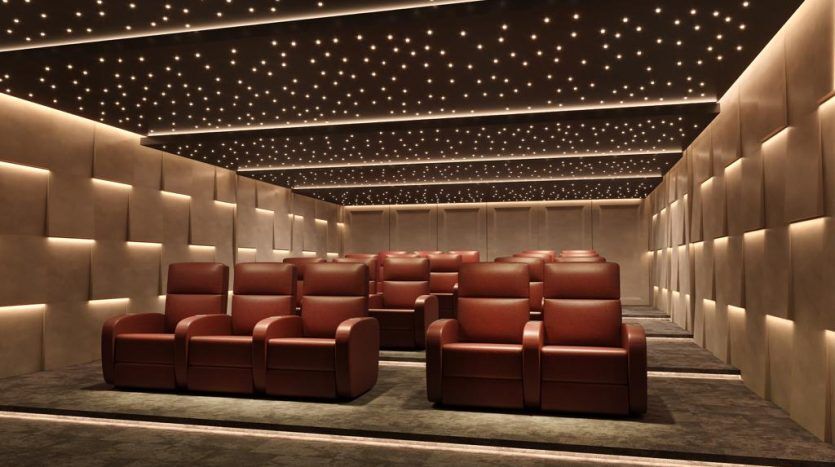 Une villa de luxe à Dubaï avec plusieurs rangées de fauteuils rouges moelleux, des murs rembourrés chaleureusement éclairés et un plafond incrusté de petites lumières en forme d'étoile.