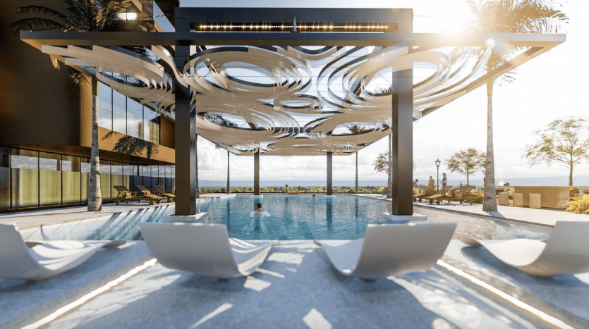 Espace piscine luxueux d'un hôtel à Dubaï avec un éclairage zénithal moderne et artistique, entouré de murs de verre, de palmiers et de chaises longues sous un ciel lumineux.