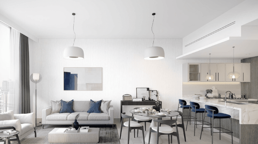 Intérieur d'appartement moderne à Dubaï présentant un design décloisonné avec un salon et une cuisine. Le salon comprend un canapé, des chaises et une table basse, tandis que la cuisine est dotée de tabourets de bar et de luminaires suspendus.
