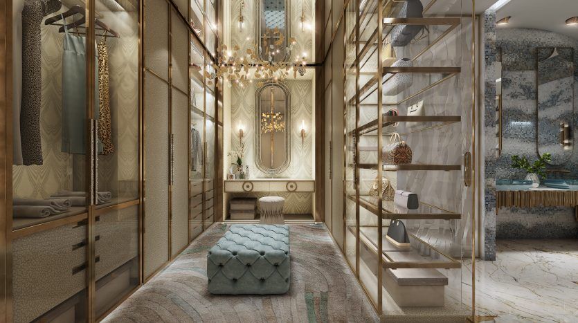 Dressing luxueux dans une villa de Dubaï avec murs en miroir, lustres élégants et étagères en verre remplies d'accessoires. Des sols en marbre et un pouf vert moelleux ajoutent au design opulent