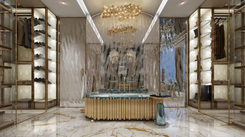 Dressing luxueux dans un appartement de Dubaï avec des sols en marbre opulents, des accents dorés, des lustres et des armoires à glace remplies de vêtements. Un îlot central offre du rangement supplémentaire.