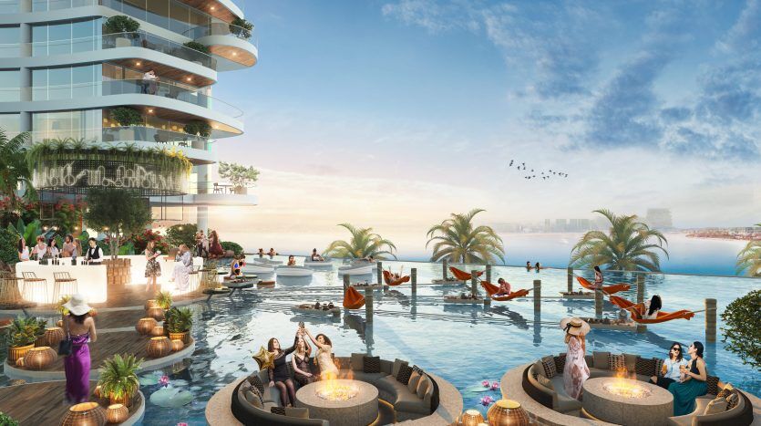Piscine luxueuse sur le toit au coucher du soleil avec des gens qui se détendent et socialisent. Cette chambre comprend plusieurs coins salons, des bougies flottantes et une vue panoramique sur le paysage urbain et la mer de Dubaï.