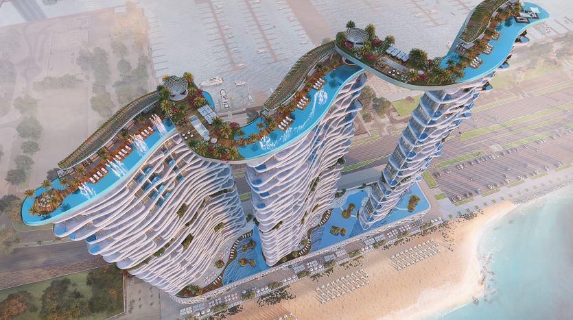 Vue aérienne d'une villa multi-tours innovante et futuriste à Dubaï avec des toits verts sinueux au bord d'une plage, reflétant une conception architecturale avancée et des concepts durables.