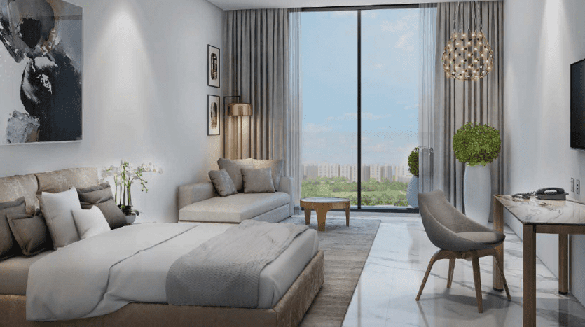 Intérieur d'un studio moderne à Dubaï avec un coin salon et chambre combiné, comprenant un grand lit, un canapé, une table à manger et une vue sur la ville à travers des fenêtres panoramiques.