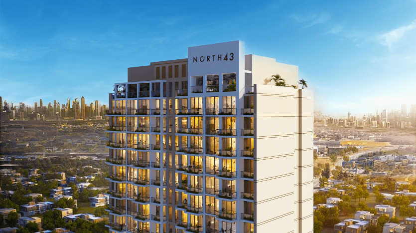 Un immeuble moderne de grande hauteur avec une pancarte indiquant "ngrth43" sur son sommet, ombragé par des palmiers, au coucher du soleil avec une ligne d'horizon de la ville en arrière-plan. Idéal pour investissement Dubaï.